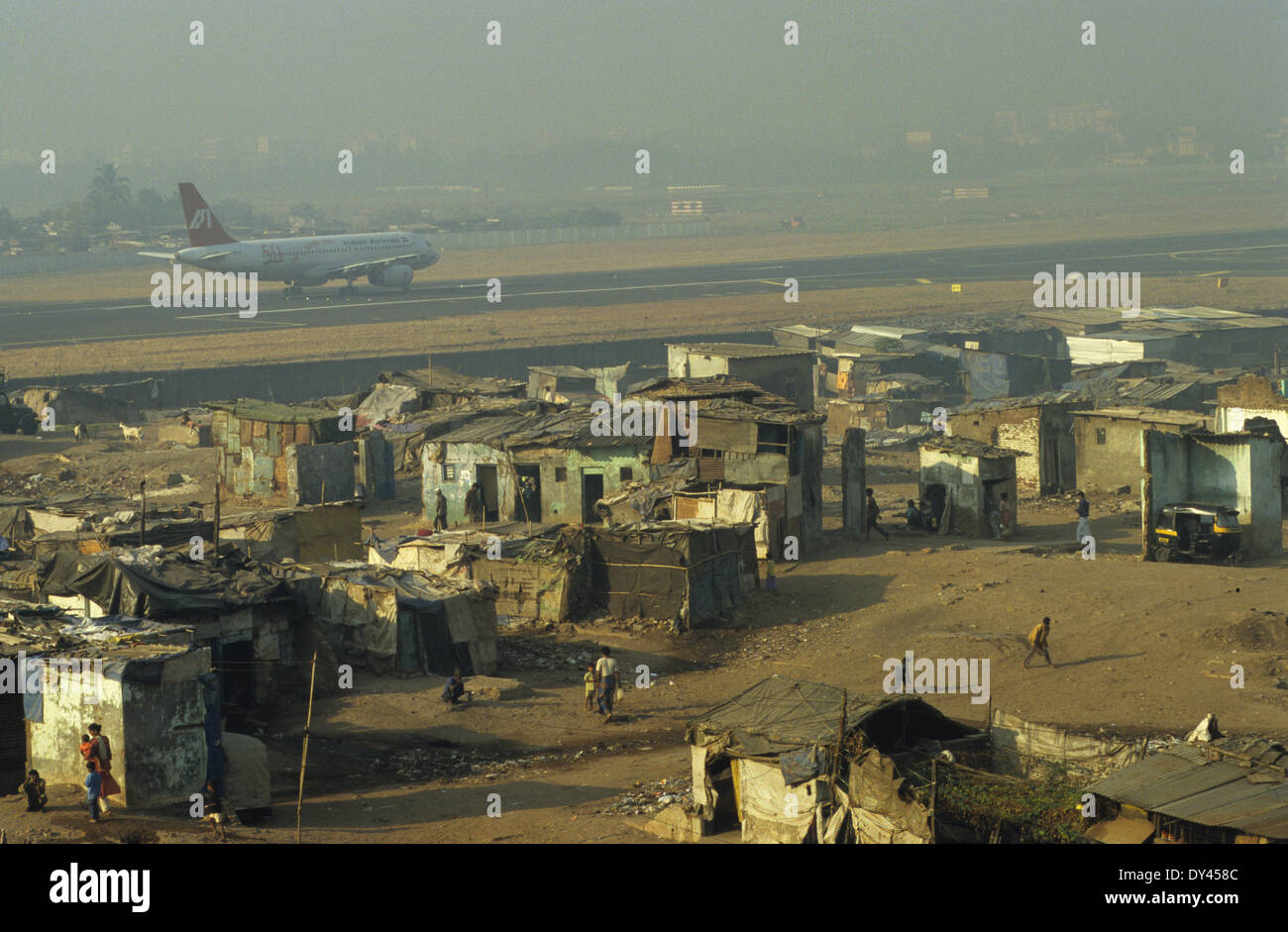 Inde Mumbai, le contraste de la pauvreté, des huttes des bidonvilles près de la piste de l'aéroport Sahar, Andheri à Boeing airplane de compagnie aérienne Indian Airlines Banque D'Images