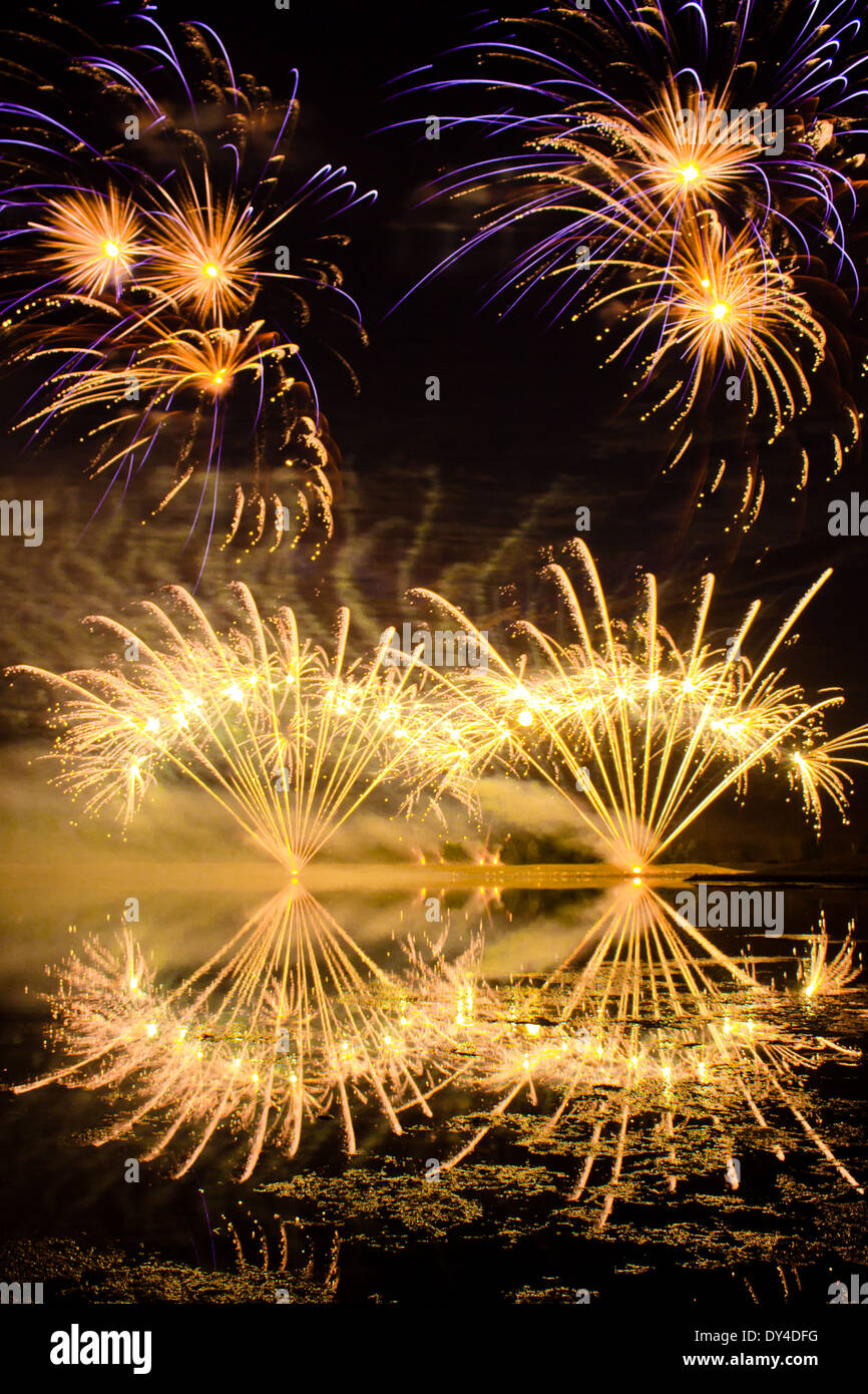 Pourpre et d'or d'Artifice reflété dans un lac Sombre Banque D'Images