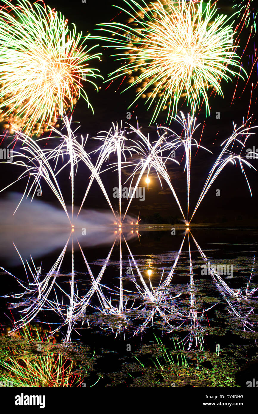 Des traînées d'Artifice bleu reflété dans un lac Sombre Banque D'Images