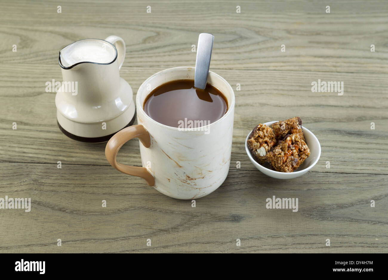 Horizontal Gros plan photo d'une pleine tasse de café, des collations et de la crème en bois vieilli avec bec verseur en dessous Banque D'Images