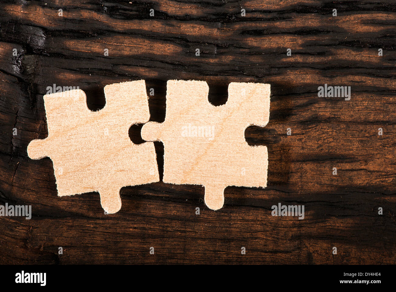 Puzzle en bois sombre sur fond de bois. Banque D'Images