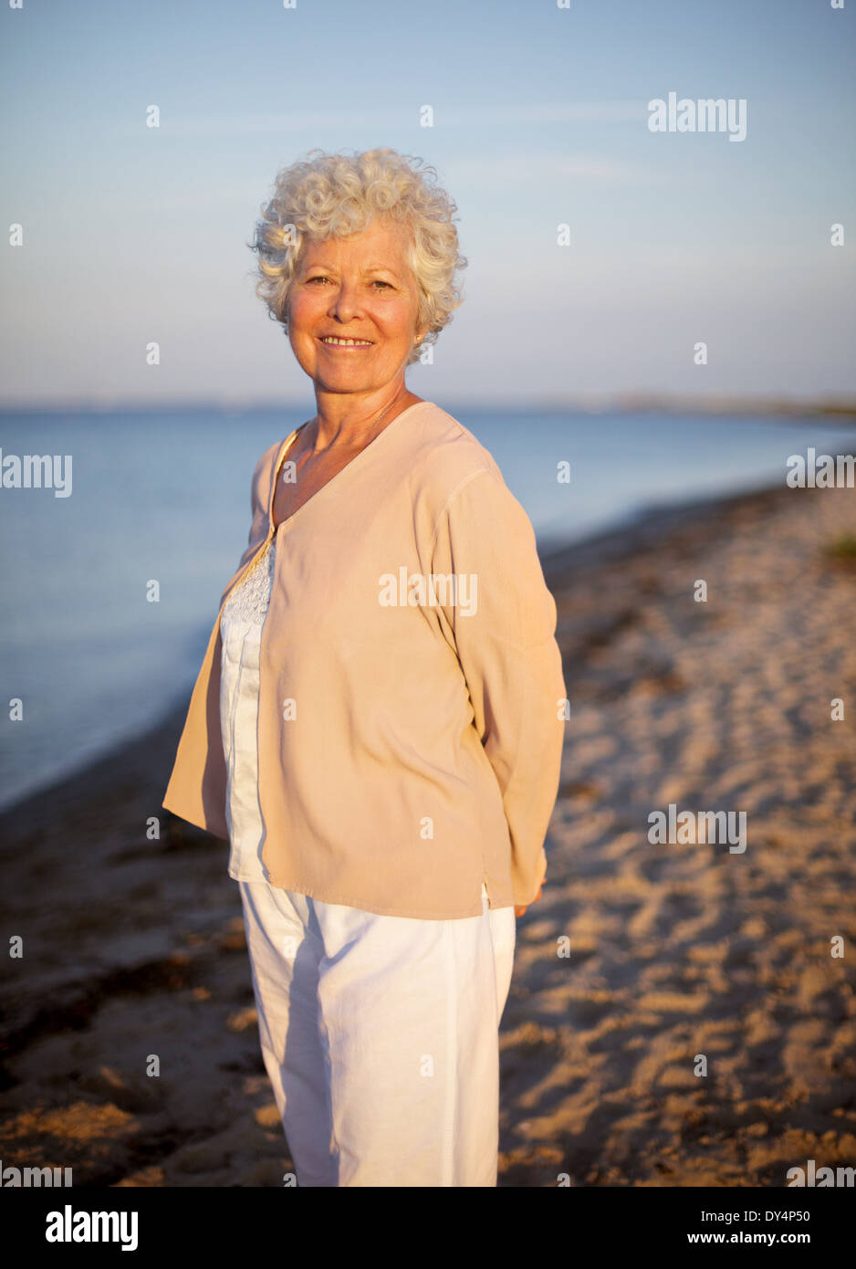 Portrait de femme d'un aîné seul se tenant sur la plage. Portrait dame de détente en plein air Banque D'Images