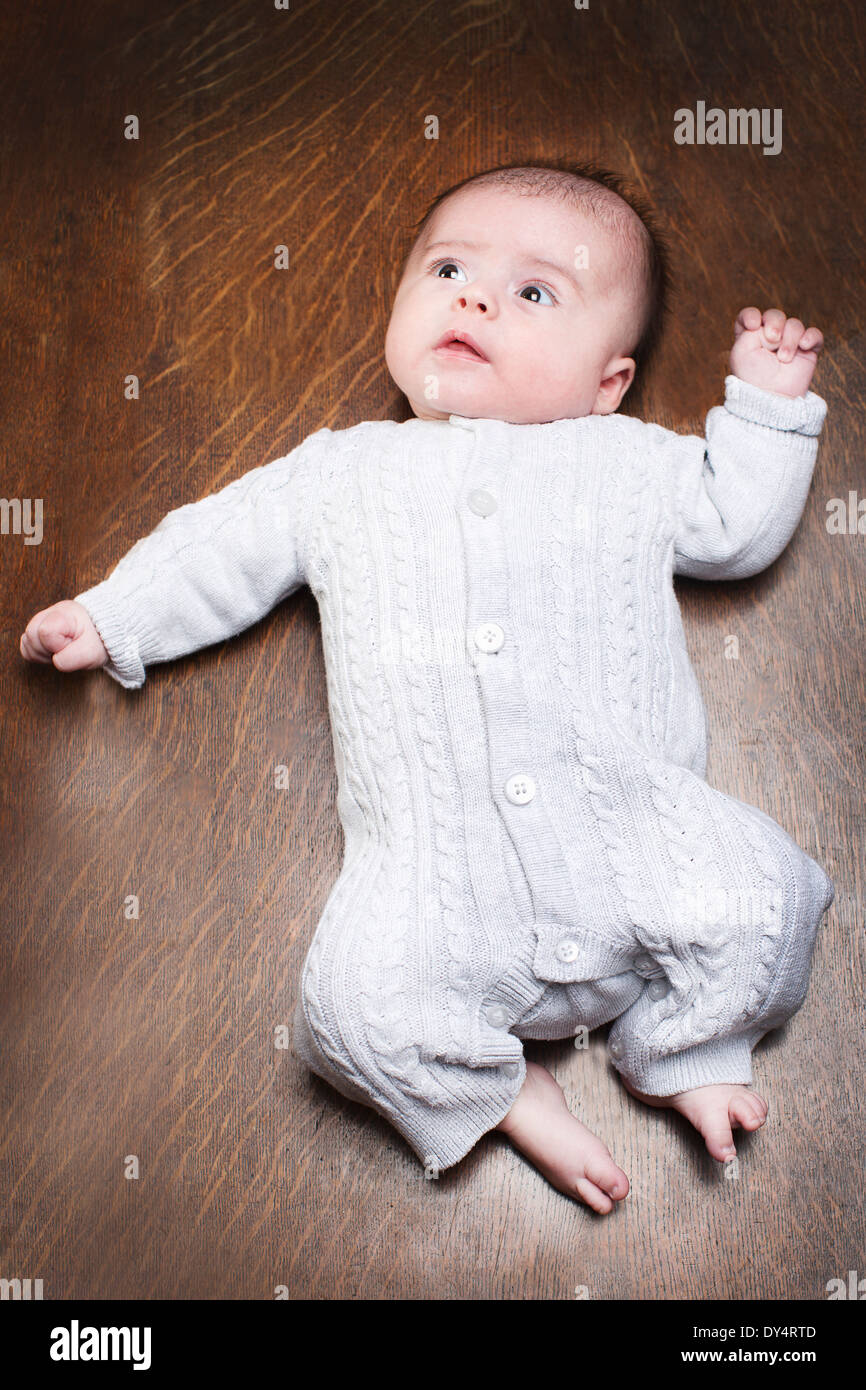 1 - 2 mois bébé garçon couché sur un plancher en bois Banque D'Images