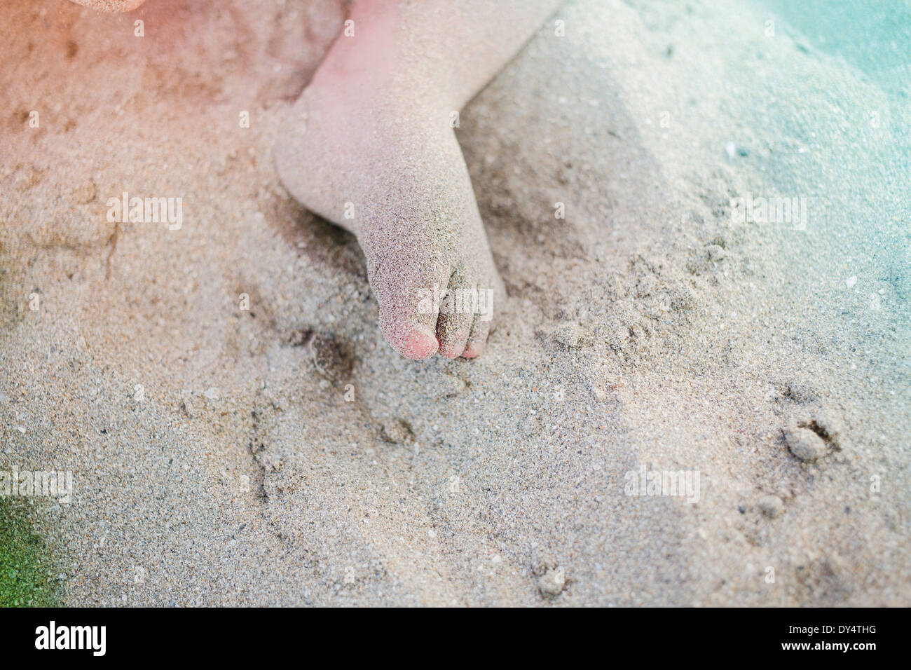 Le pied de l'enfant, couvert de sable Banque D'Images