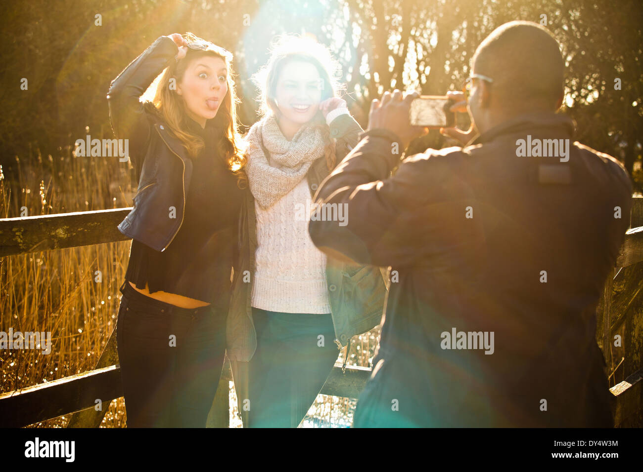 Young man photographing female friends Banque D'Images