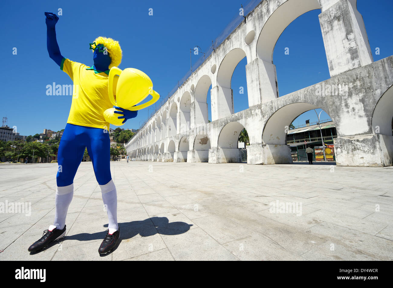 Joueur de football brésilien bleu excité holding trophy célébrer en couleurs de l'équipe à Rio de Janeiro Banque D'Images