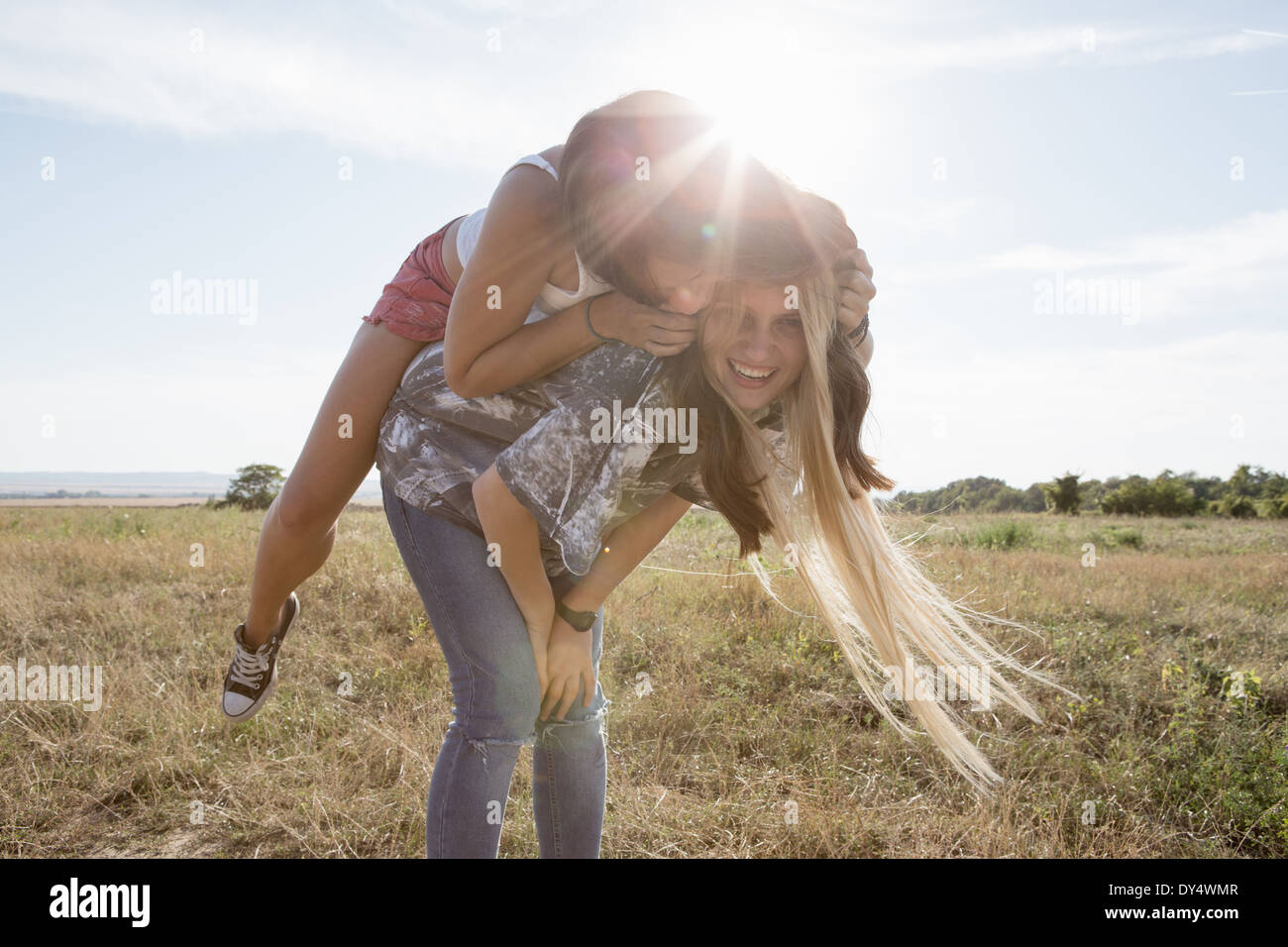 Young woman giving ami piggy back Banque D'Images