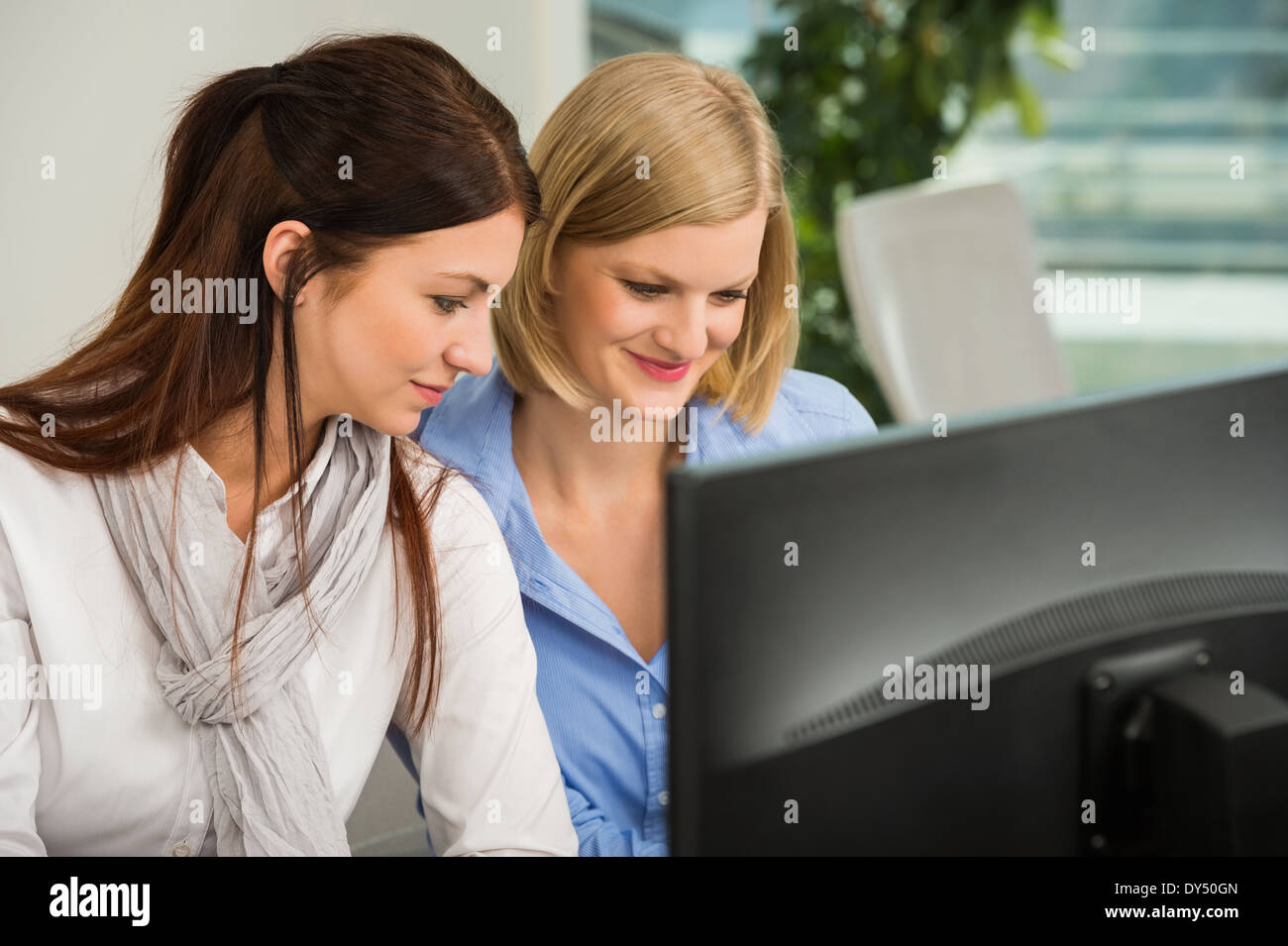 Les jeunes à la recherche d'affaires à l'écran de l'ordinateur de bureau Banque D'Images