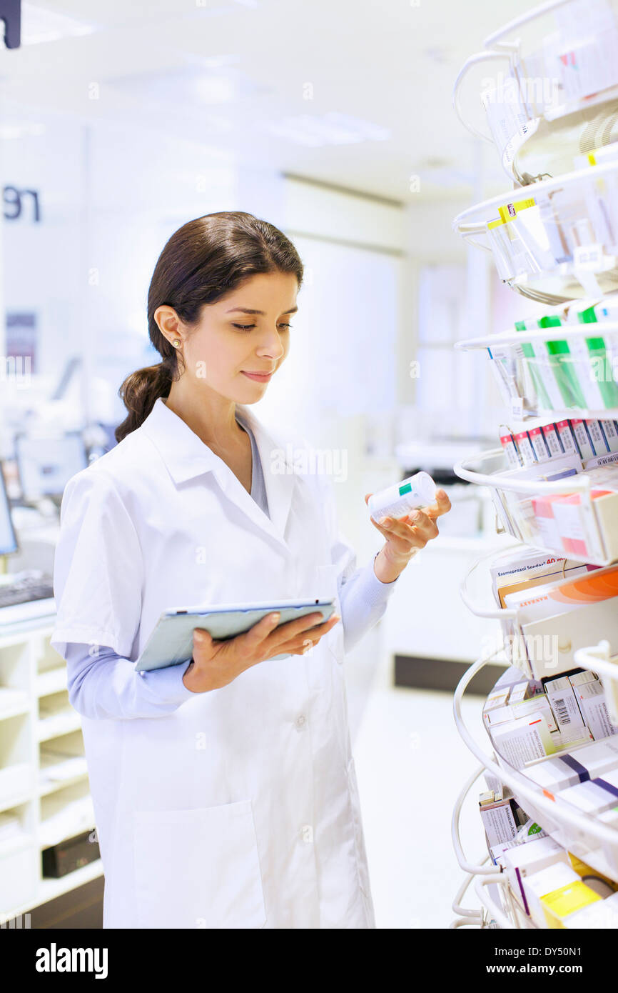 Young female pharmacist la prise de stock en pharmacie Banque D'Images