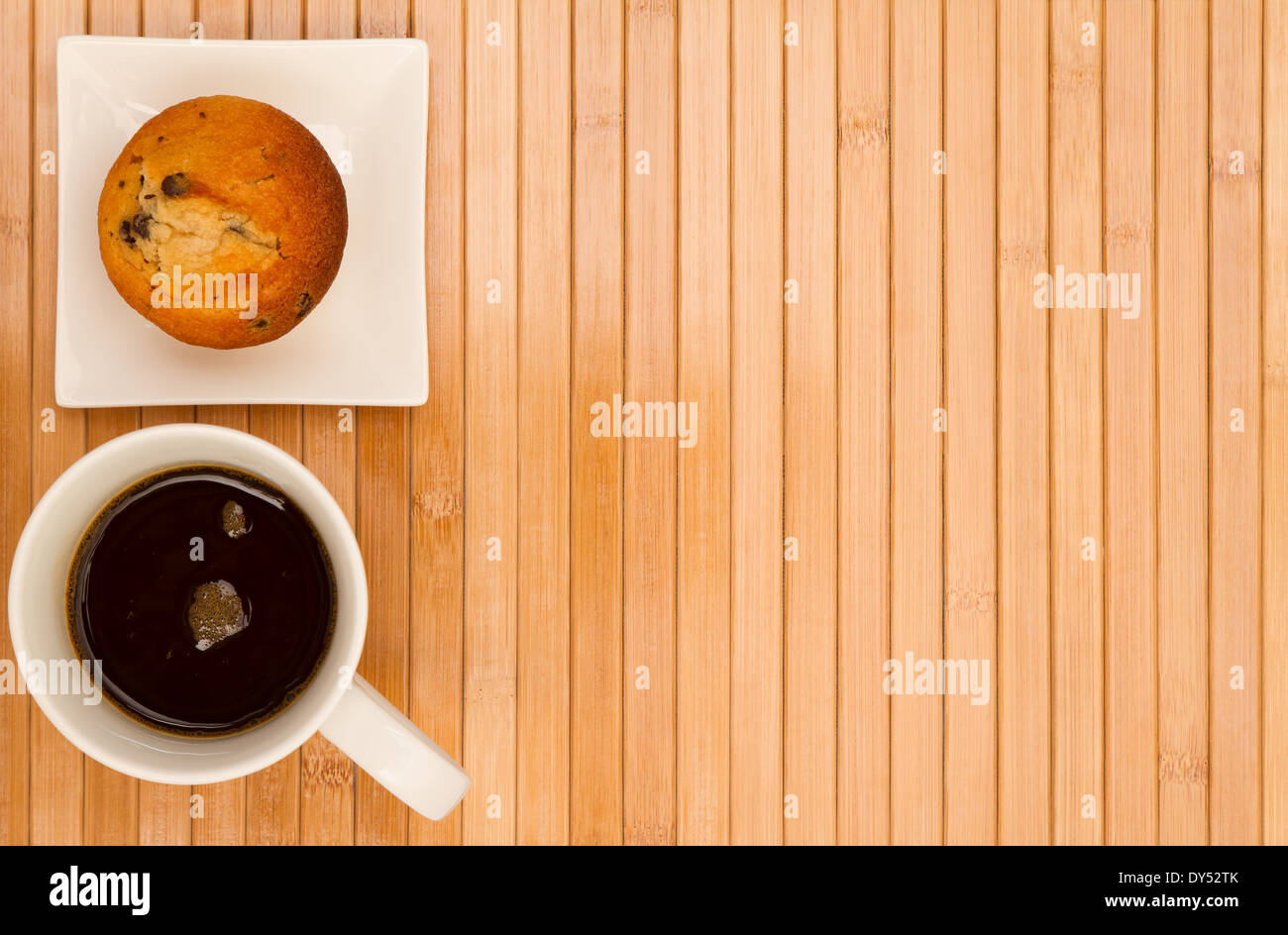 Muffin à la vanille aux pépites de chocolat sur une plaque blanche avec une tasse de café Banque D'Images