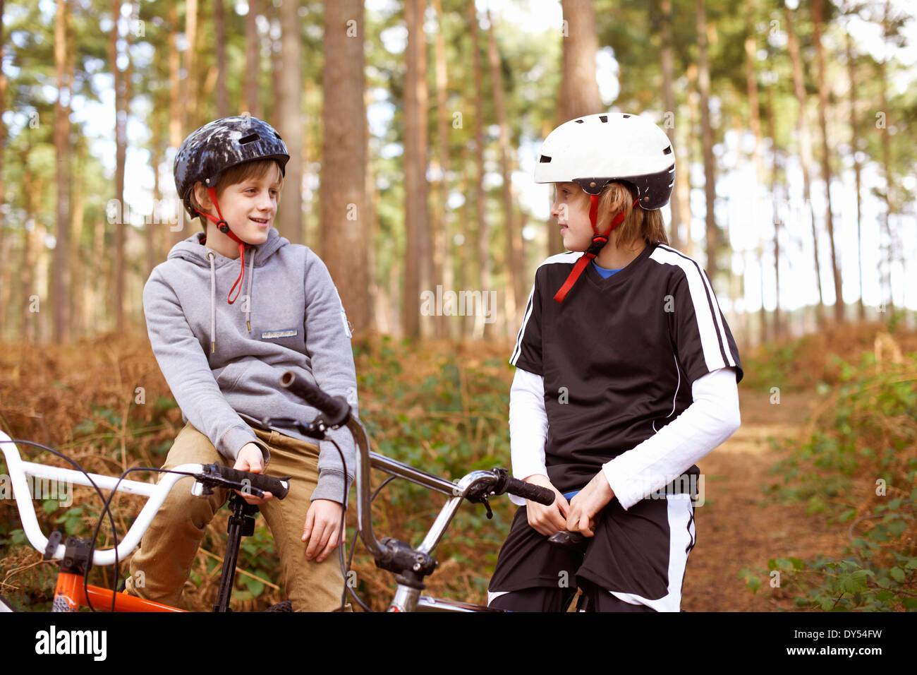 Les frères jumeaux sur vélos BMX chatting in forest Banque D'Images