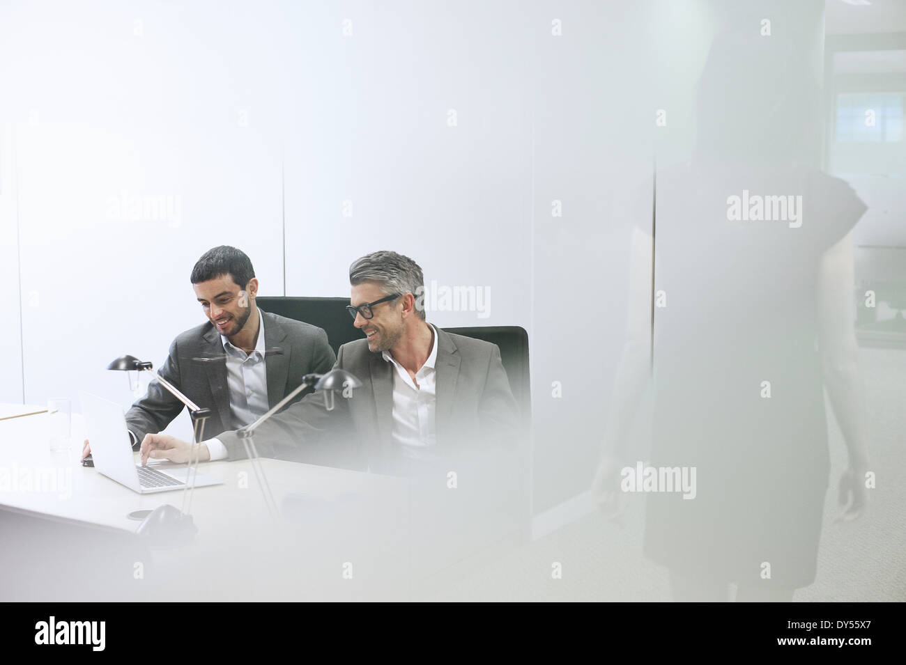 Des collègues masculins using digital tablet in office Banque D'Images