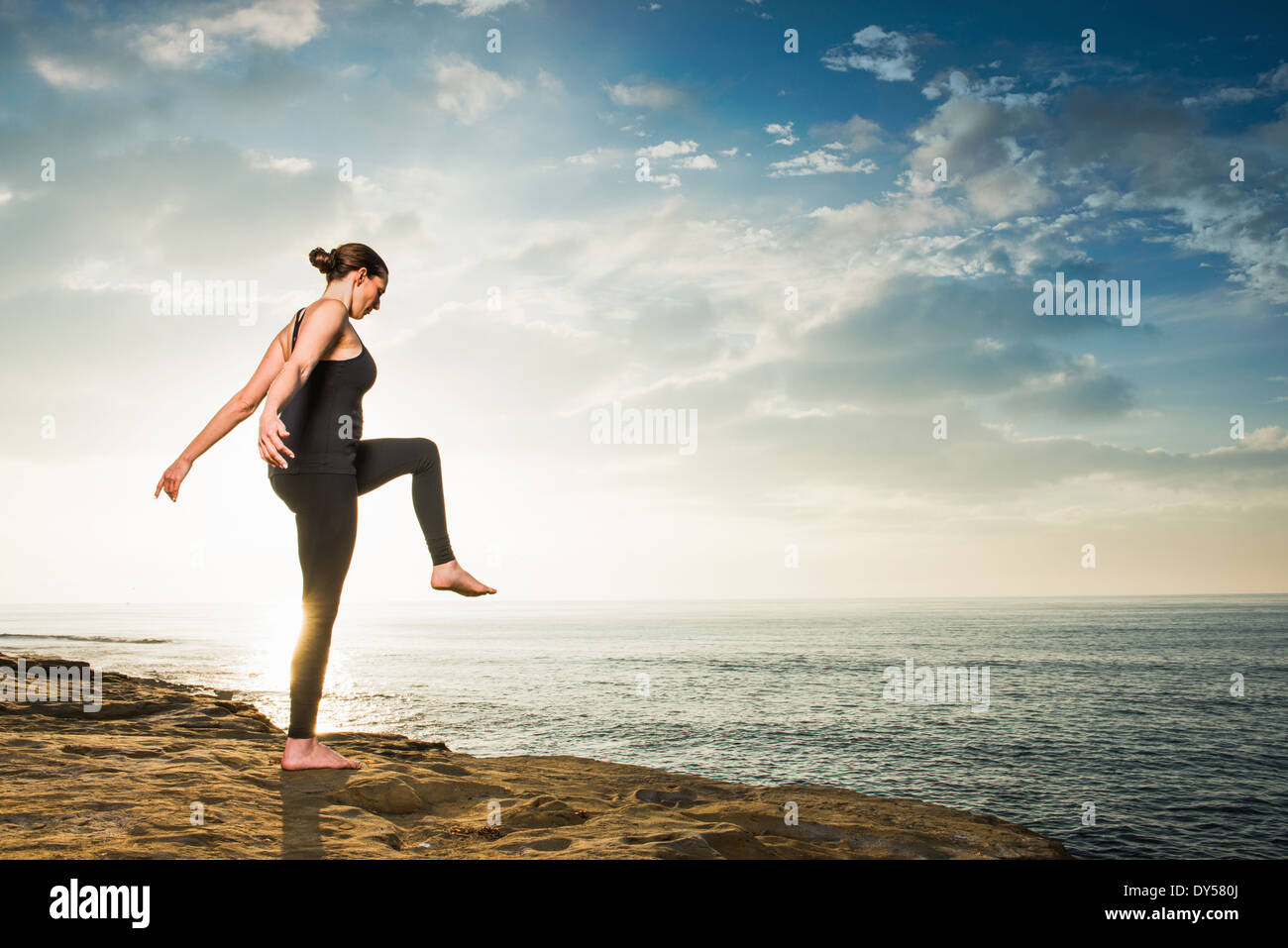Women on cliff, in yoga position Banque D'Images