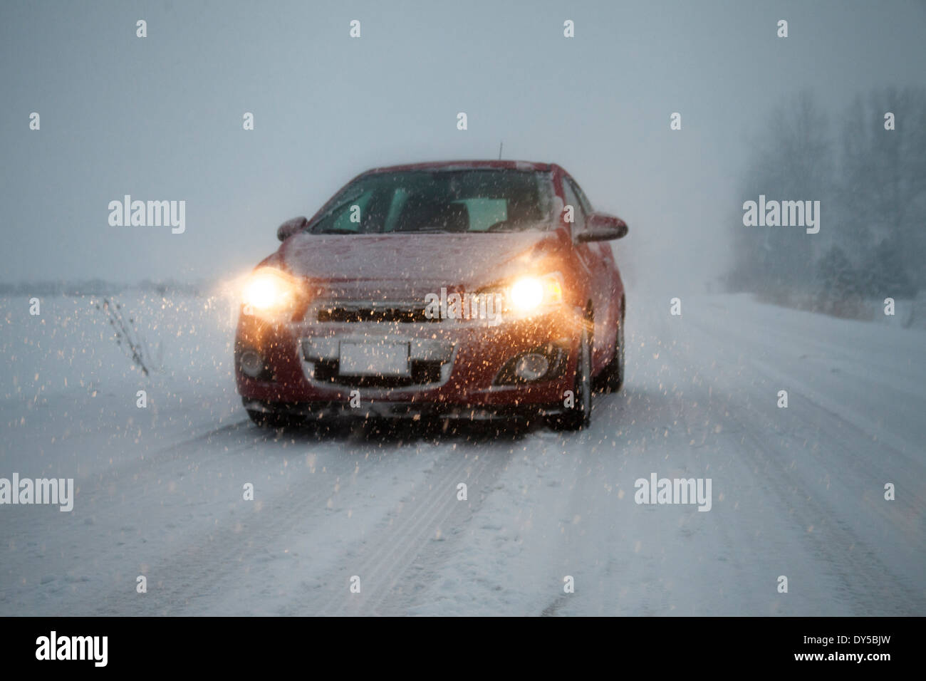 Voiture avec phares sur conduite le long de la route couverte de neige brouillard Banque D'Images