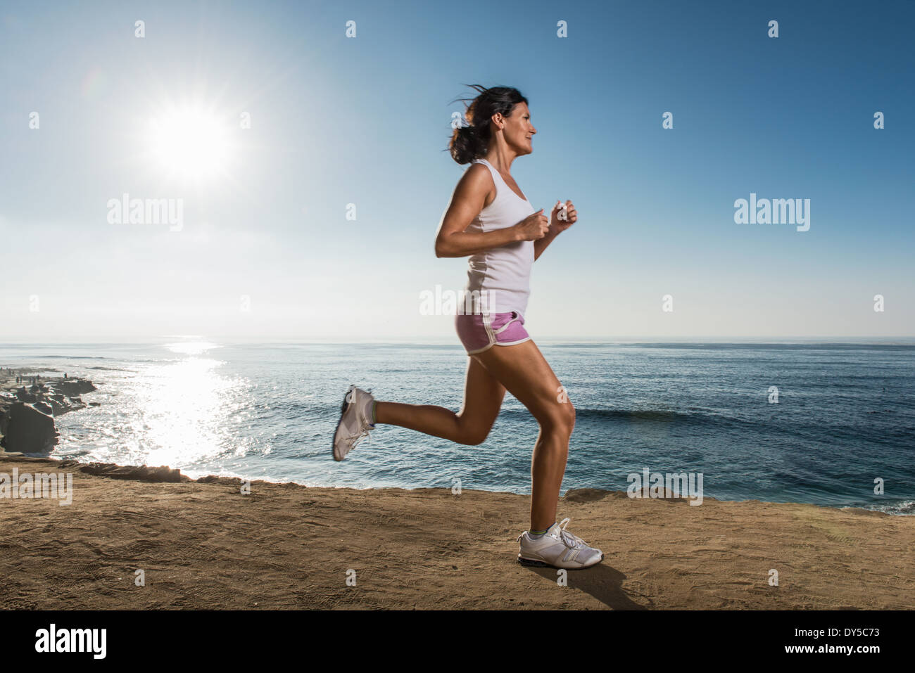 Mid adult woman jogging le long de falaise Banque D'Images