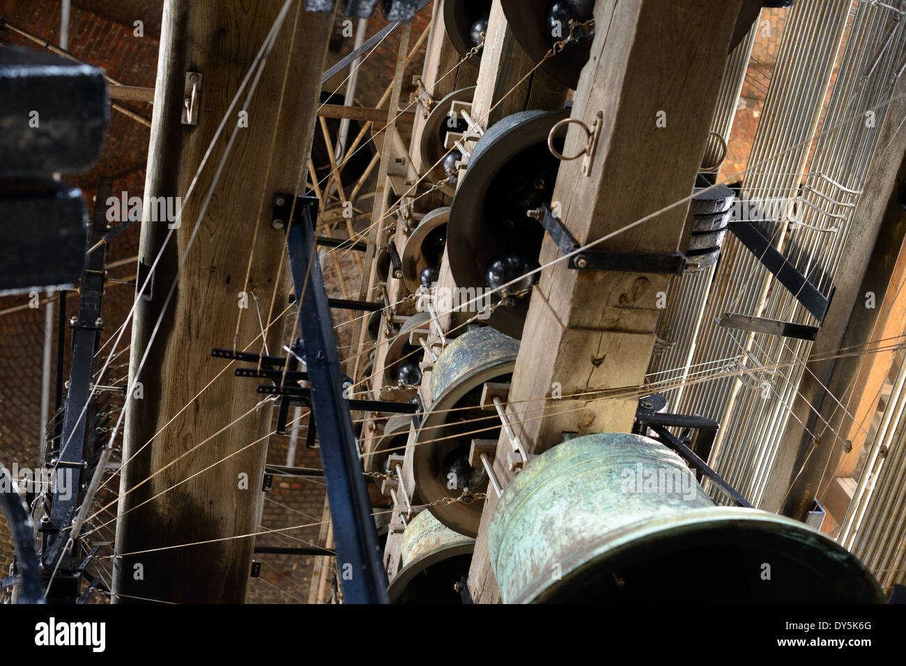 BRUGES, Belgique — les cloches de carillon historiques du beffroi de Bruges combinent des siècles de tradition de moulage de cloches, avec 26 cloches Dumery du XVIIIe siècle et 21 cloches Eijsbouts modernes. Ensemble, ces 47 cloches, pesant un total de 27 tonnes, créent les sons distinctifs qui ont sonné au-dessus de Bruges depuis des générations. La gigantesque cloche abrite à la fois des exemples historiques et contemporains de l'artisanat de moulage de cloches. Banque D'Images