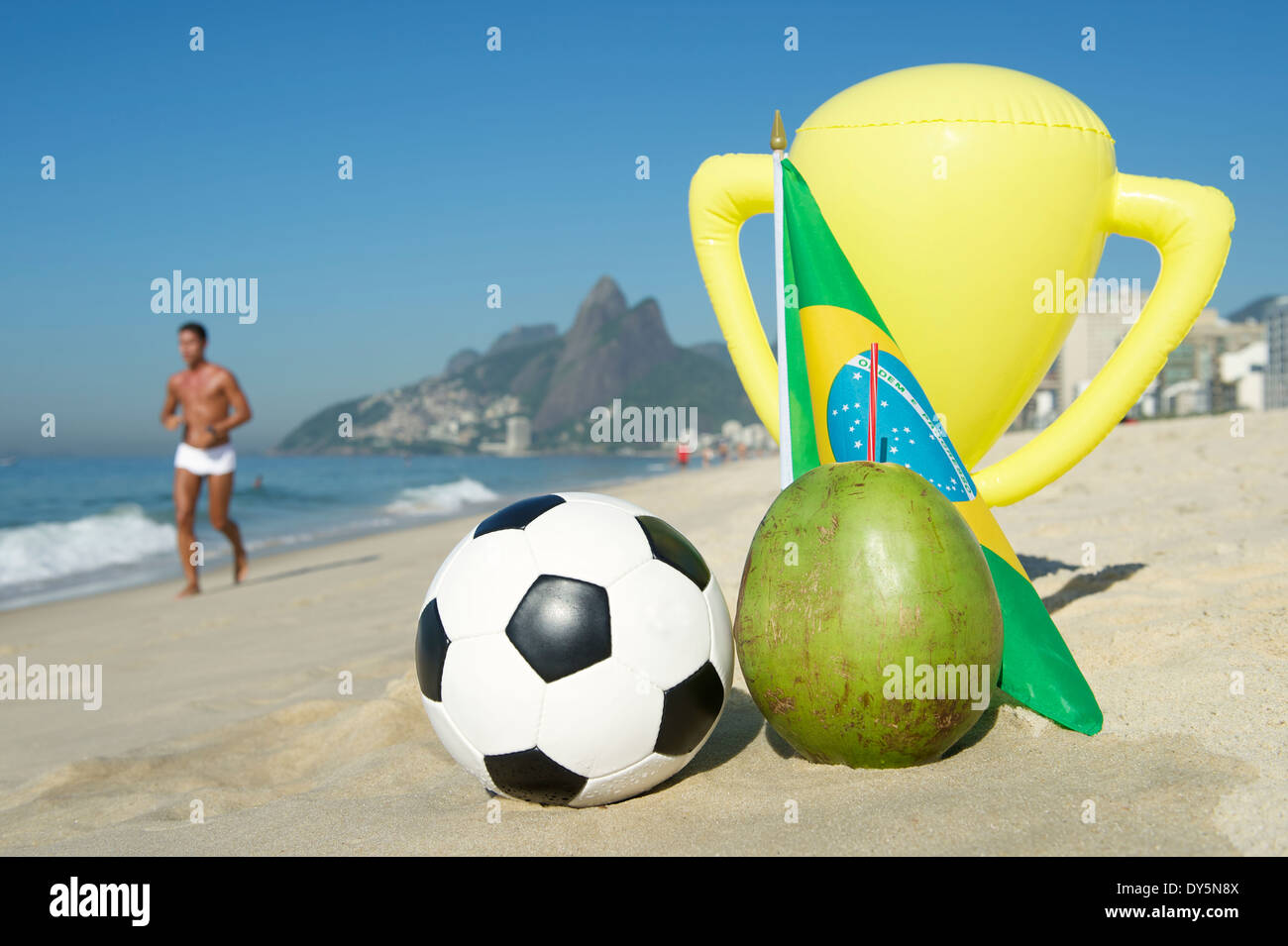 Le Brésil champion soccer trophy avec football, noix de coco, et drapeau brésilien sur la plage d'Ipanema Rio de Janeiro Brésil Banque D'Images