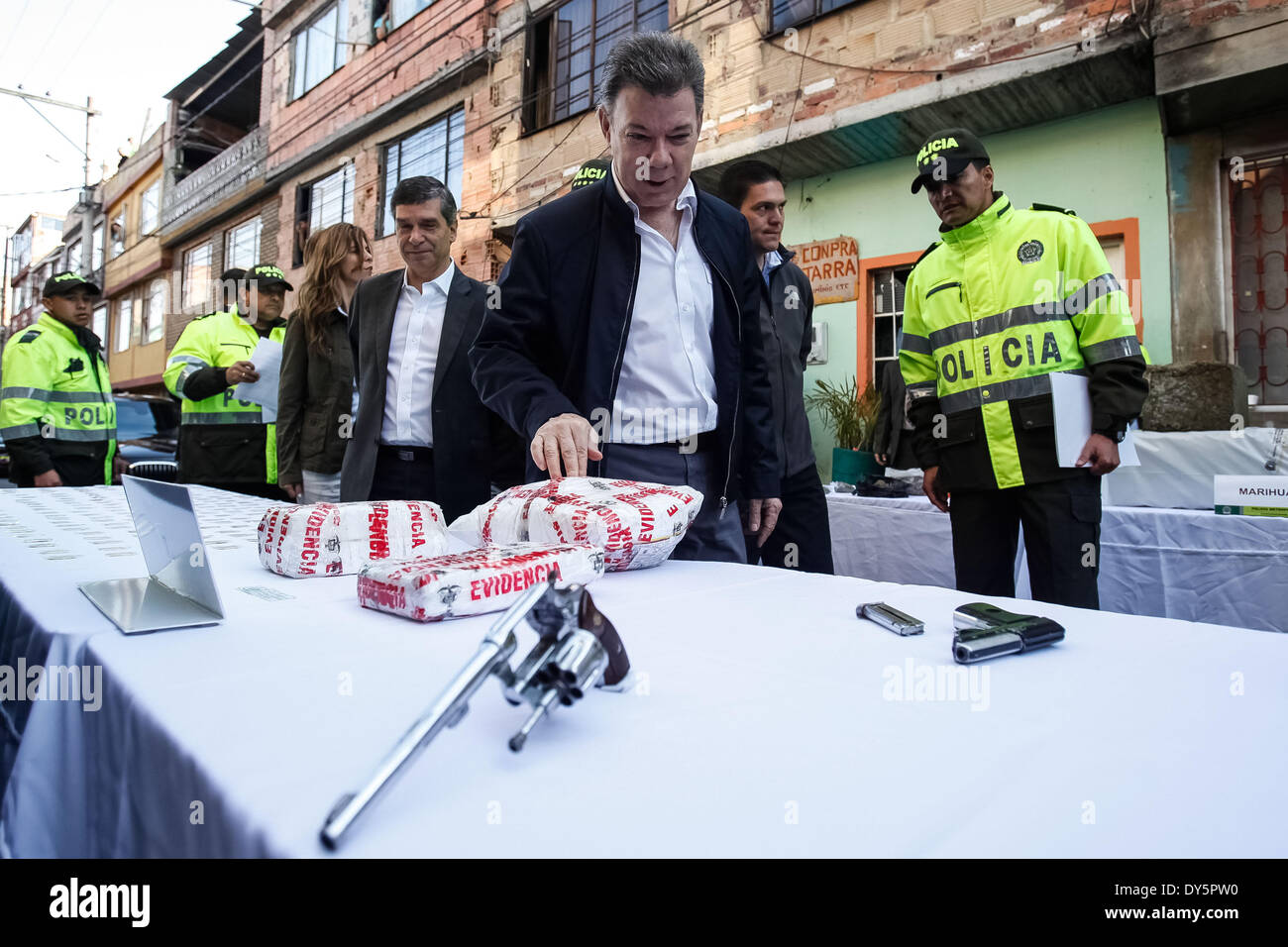 Bogota, Colombie. Apr 11, 2014. Le président colombien Juan Manuel Santos (C), les montres une saisie de cocaïne au cours d'une opération contre l'appelé 'Pots' à Bogota, capitale de la Colombie, le 11 avril 2014. Santos a lancé jeudi un nouveau plan de lutte contre l'microtraffic de démolir les structures dans ceux qui appliquent le 'pot' de drogues illicites et d'armes, selon la presse locale. Credit : Jhon Paz/Xinhua/Alamy Live News Banque D'Images
