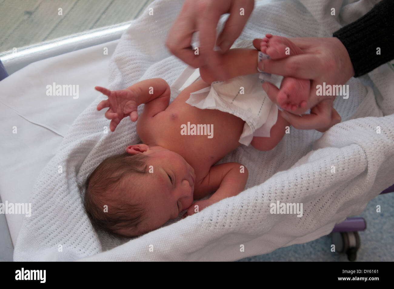 Naissance bebe Fille être habillé pour la première fois par son père Banque D'Images