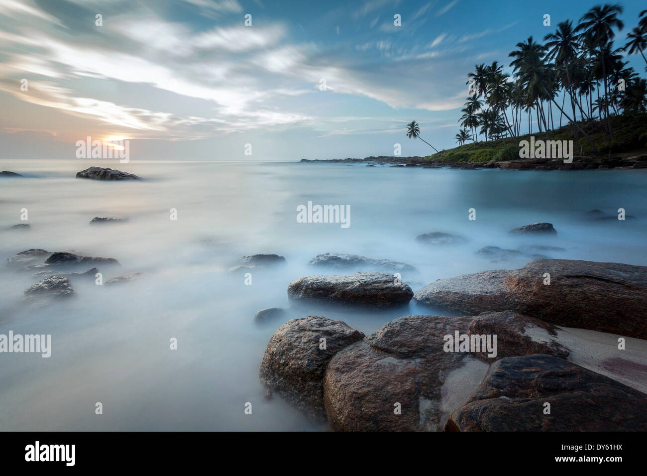 Lever du soleil à une lagune isolée avec des pierres et de palmiers sur le cadrage, Tangalle, au Sri Lanka, de l'Océan Indien, l'Asie Banque D'Images