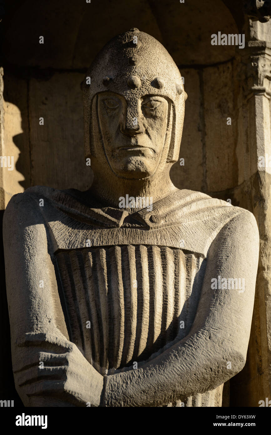 Statue de chevalier de l'hôtel de ville Bruges Belgique // BRUGES, Belgique — des statues médiévales de chevaliers, de clergés et de nobles ornent la façade gothique de l'hôtel de ville de Bruges (Stadhuis), construit en 1376. L'extérieur du bâtiment présente des décorations sculpturales élaborées, y compris des boucliers héraldiques représentant des territoires historiquement gouvernés depuis Bruges. Ces éléments architecturaux démontrent l'importance politique et culturelle médiévale de la ville. Banque D'Images