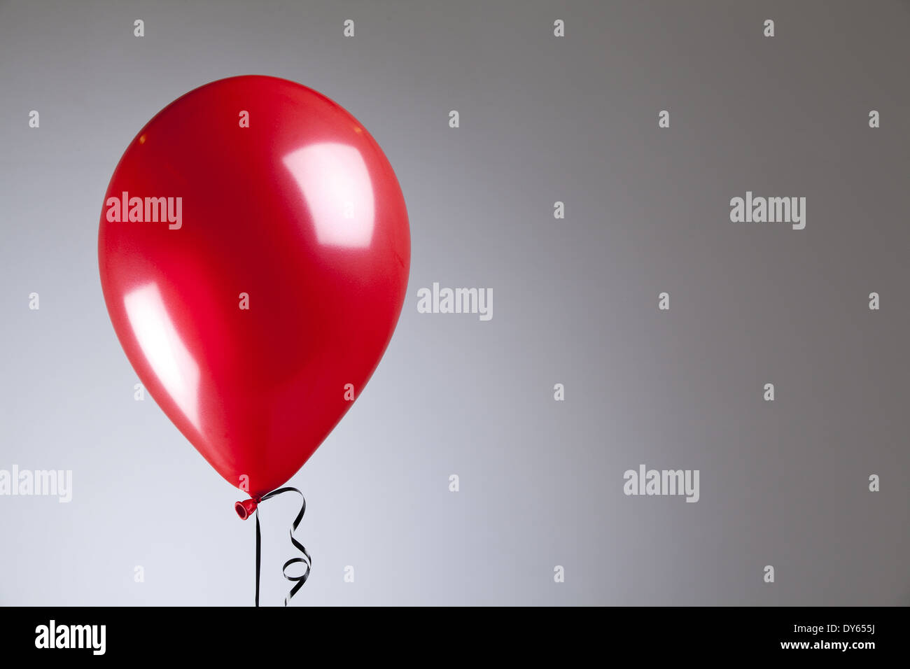 Ballons rouge brillant sur fond gris Banque D'Images