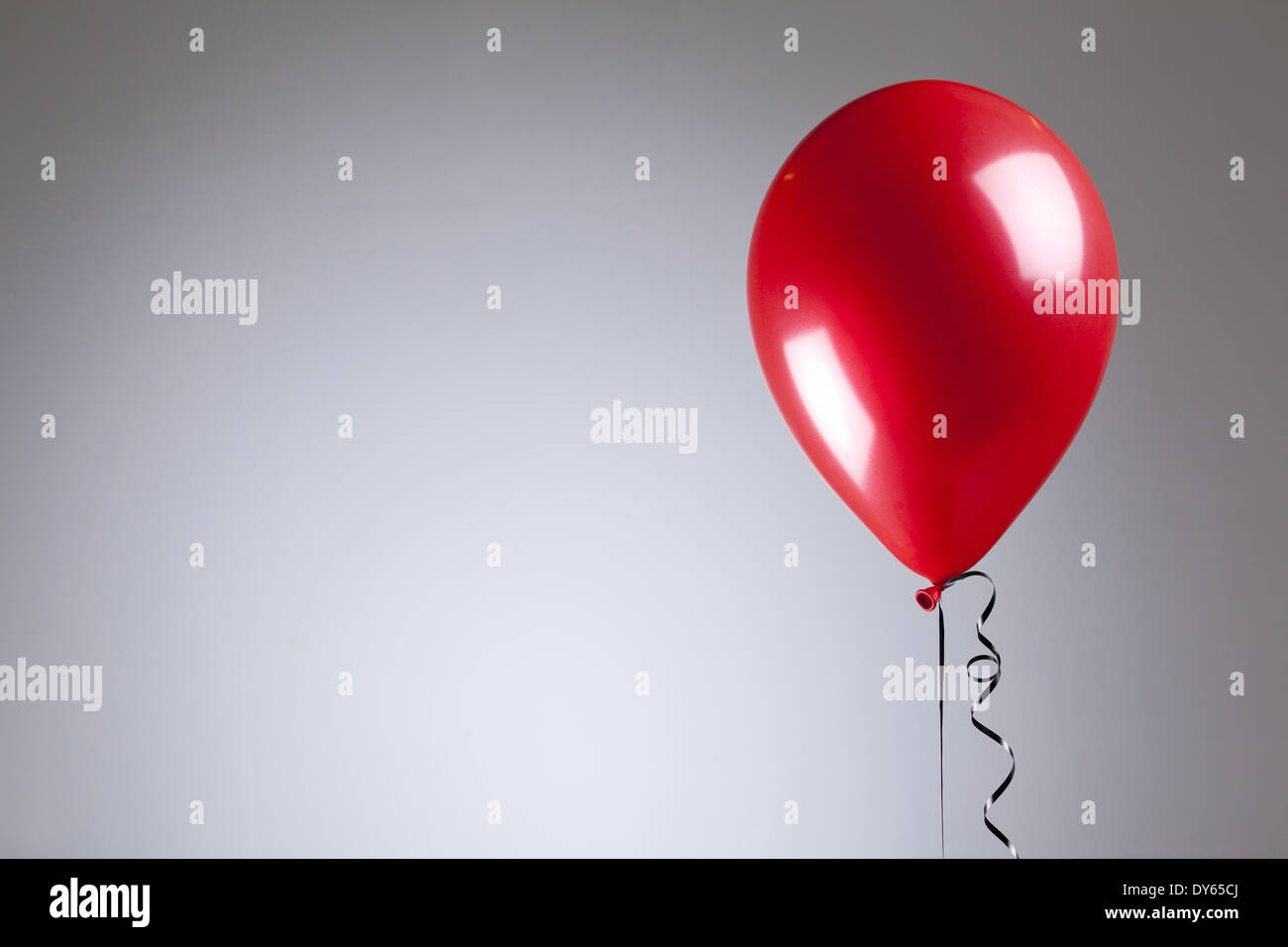 Ballons rouge brillant sur fond gris Banque D'Images