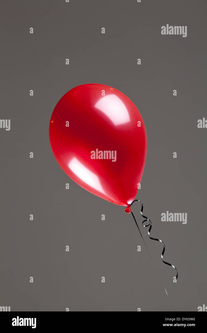 Ballons rouge brillant sur fond gris Banque D'Images