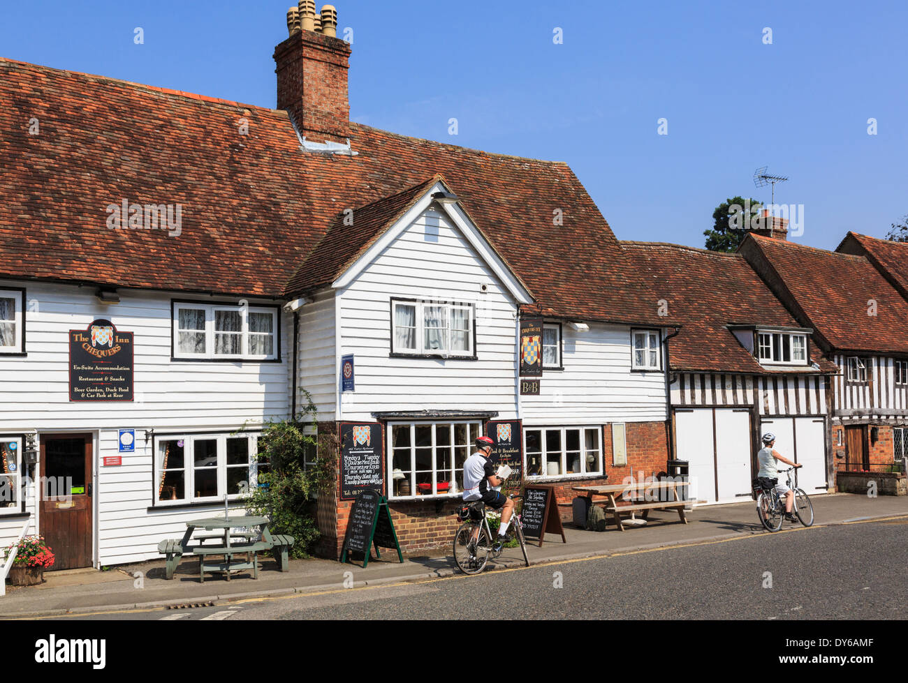 Les cyclistes se reposer par le Chequers Inn 14thc village pub dans un vieux bâtiment blanc Kentish Clin North Harrow en Angleterre Kent Royaume-Uni Grande-Bretagne Banque D'Images