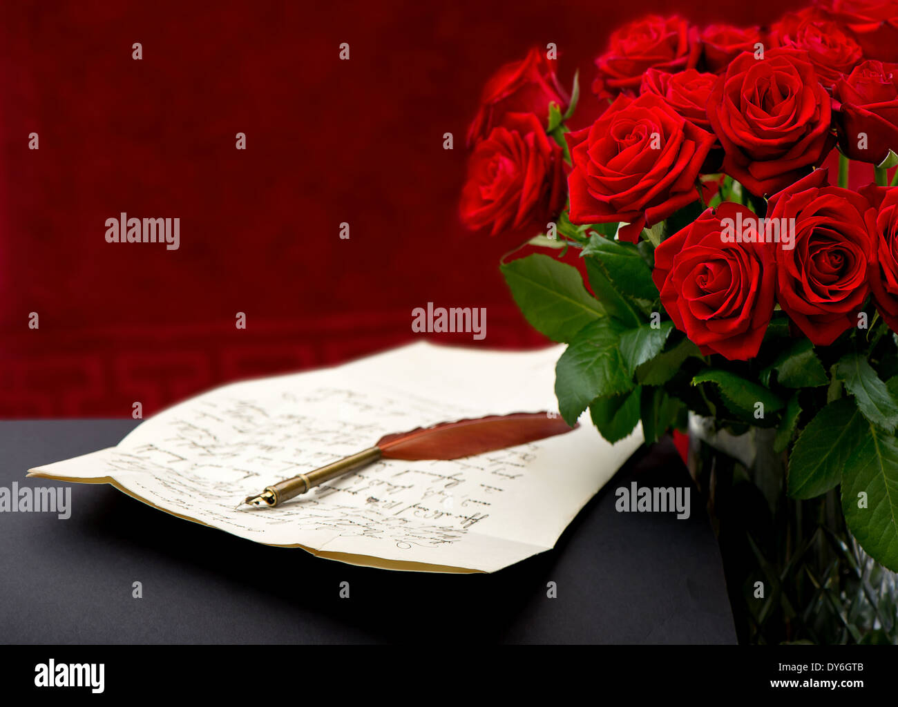 Bouquet de roses rouges avec lettre manuscrite sur fond noir Banque D'Images