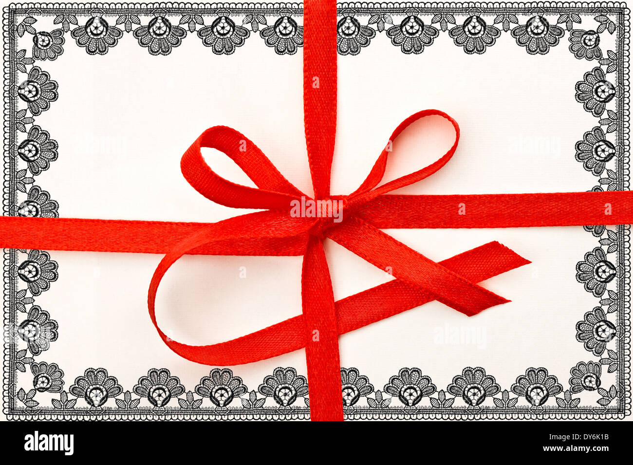 Carte-cadeau avec ruban rouge et cadre dentelle Banque D'Images