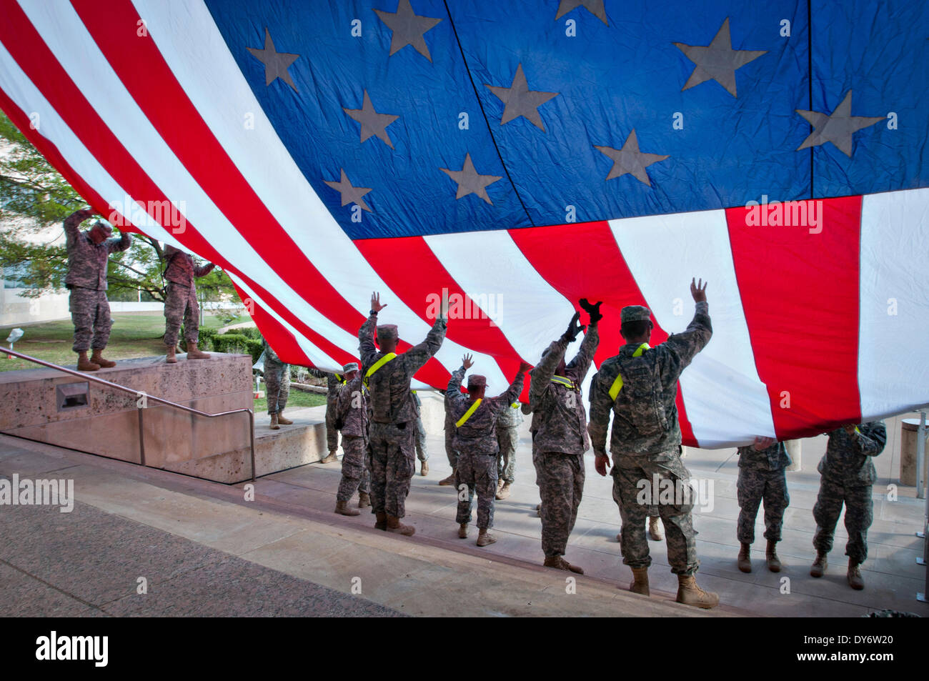 Les soldats de l'Armée US avec la Division de cavalerie accrocher un drapeau américain à partir du 3è Corps d'administration centrale à Fort Hood en préparation pour un service commémoratif en hommage aux victimes de la fusillade du 2 avril sur la base, 7 avril 2014. Le président Barack Obama et Première Dame Michelle Obama devaient assister à la cérémonie le 9 avril. Banque D'Images