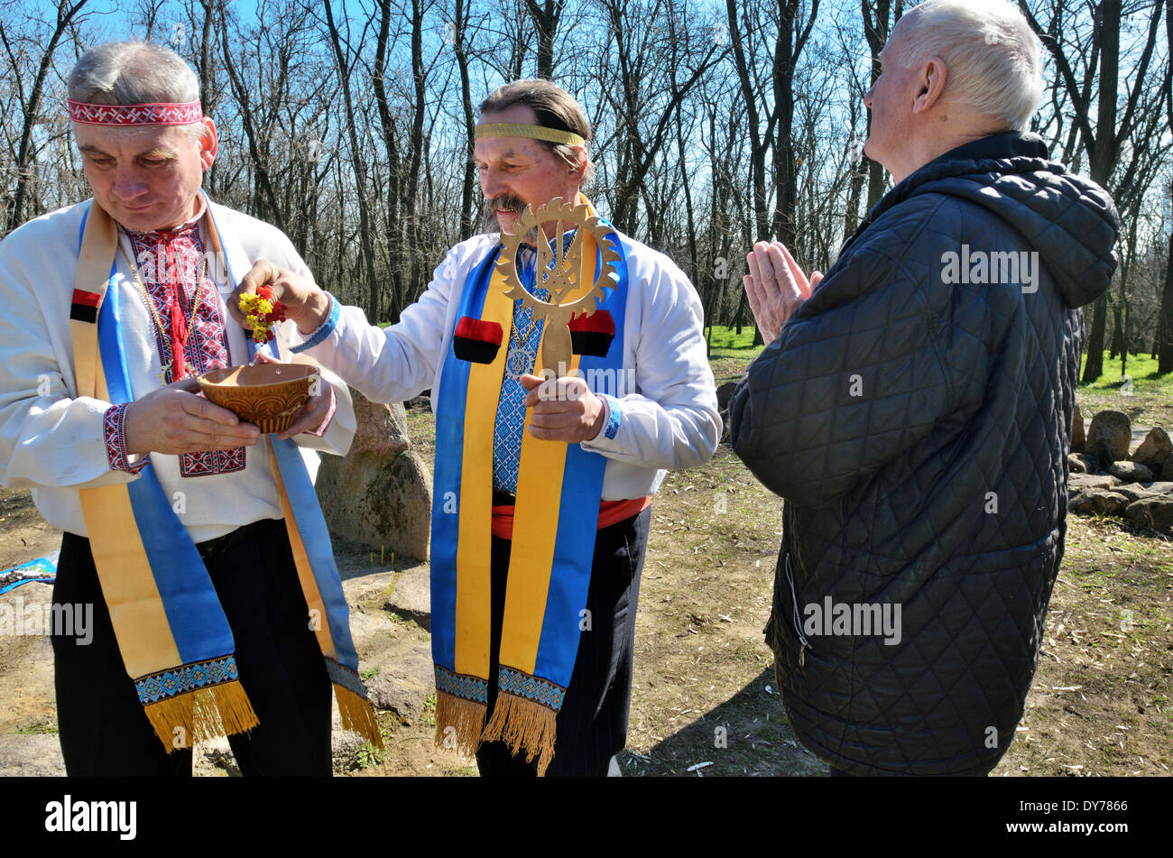 Les rituels païens protoslave en Ukraine. Prêtre bénir l'adorateur par l'eau et de fleurs. Banque D'Images