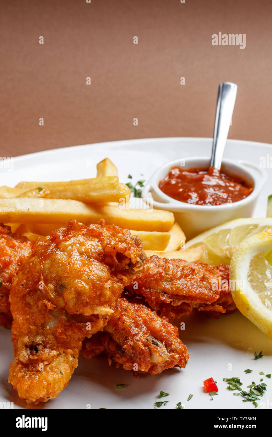 Cuisses de poulet pané épicé avec des pommes de terre Banque D'Images