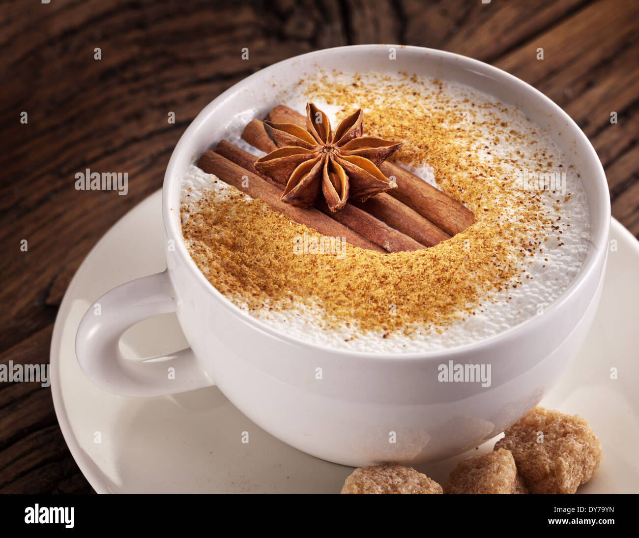 Tasse de cappuccino décoré avec des épices et des cubes de sucre brun près de lui. Banque D'Images