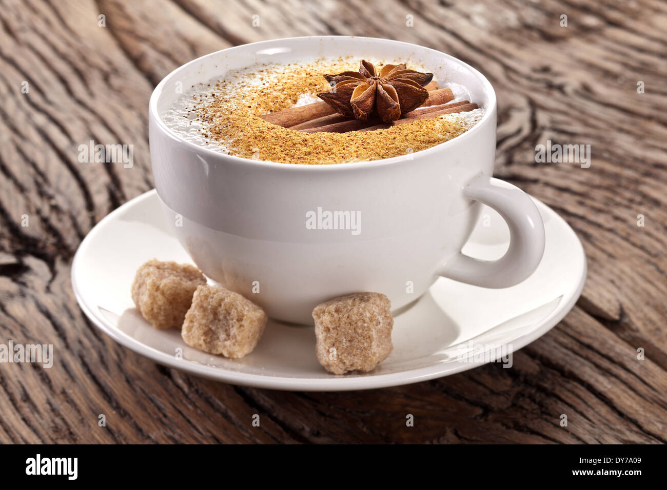 Tasse de cappuccino décoré avec des épices et des cubes de sucre brun près de lui. Banque D'Images