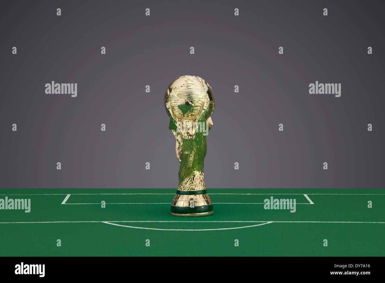 Mini réplique du trophée de la Coupe du Monde de football sur un terrain de foot en tissu Banque D'Images