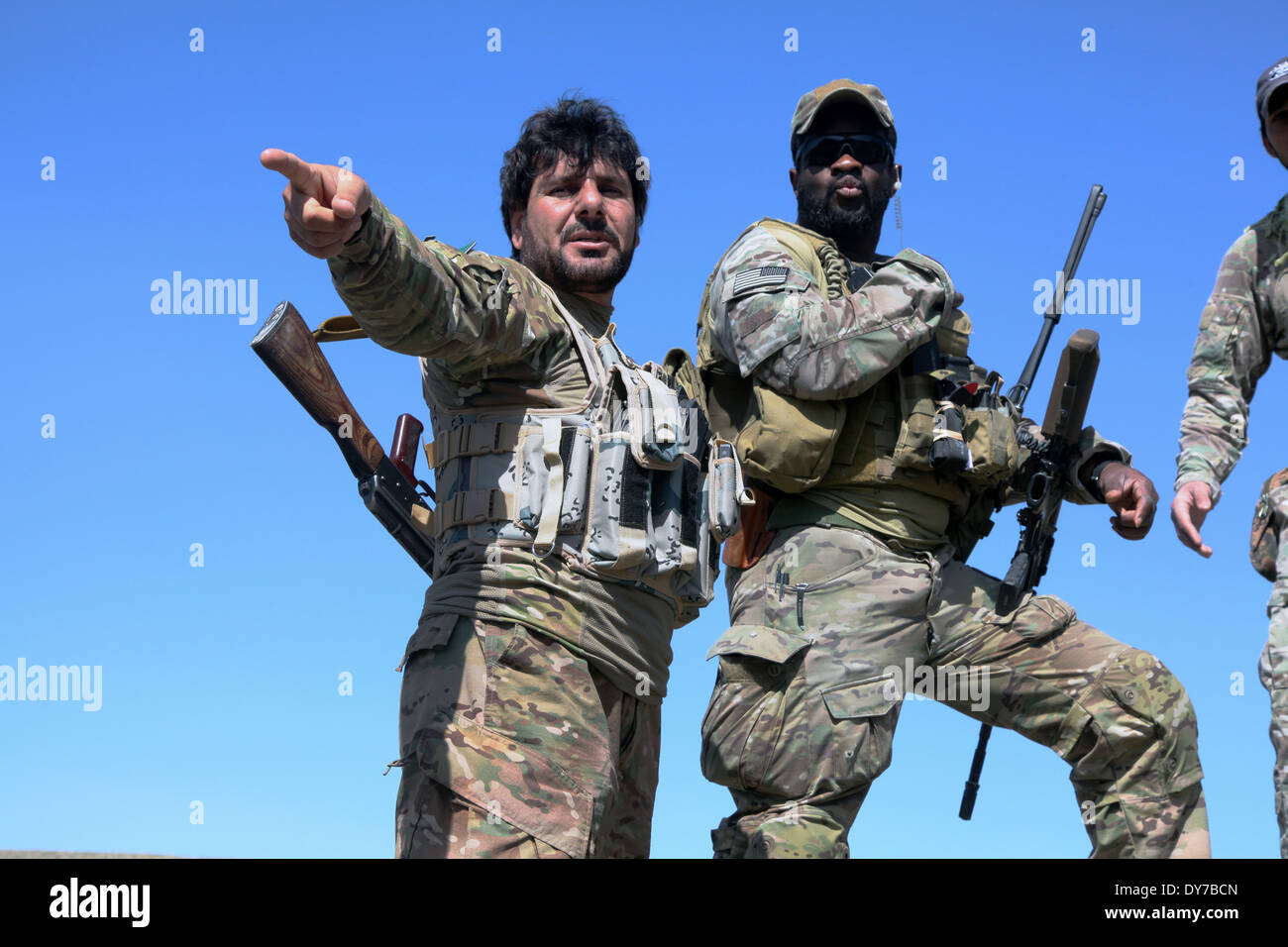 Un commandant de la police locale afghane de l'armée américaine avec un soldat des forces d'opérations spéciales discuter où construire un checkpoint 18 Mars, 2014 dans Nanghlu district, province de Kaboul, Afghanistan. Banque D'Images
