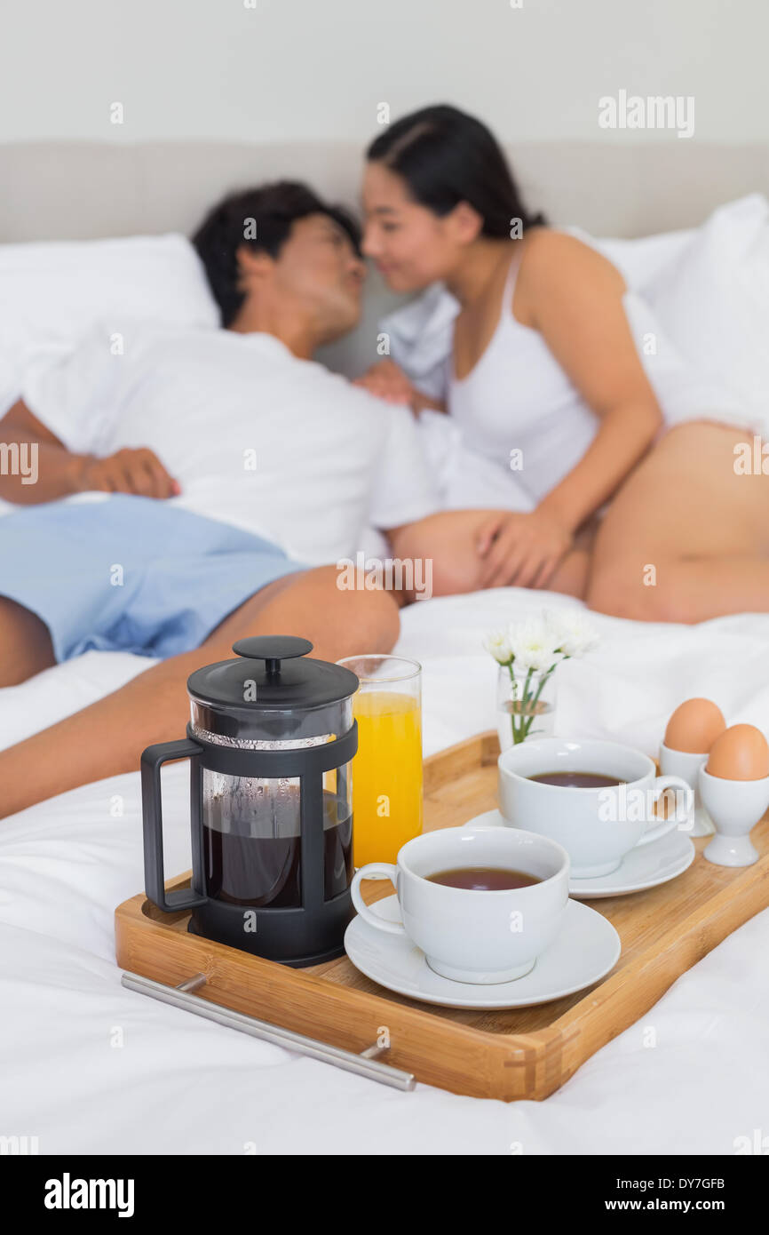 Affectionate couple having breakfast in bed Banque D'Images