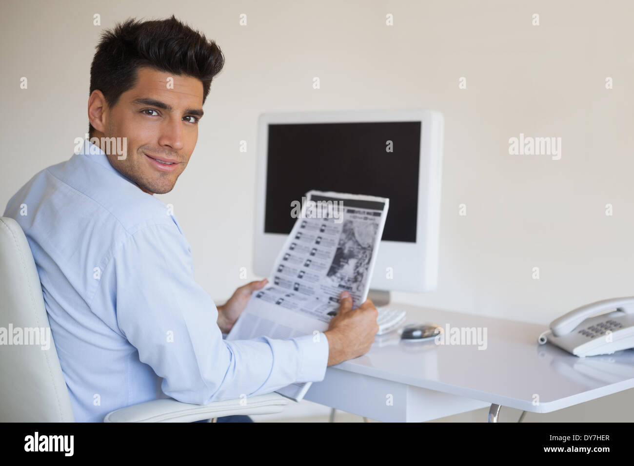 Businessman reading newspaper à son bureau. Banque D'Images