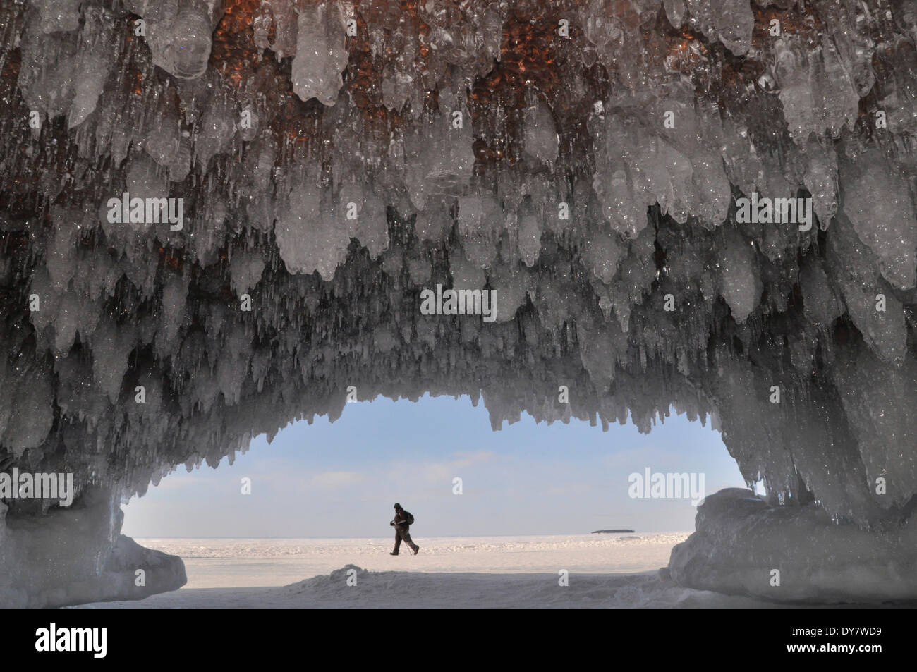 Formations de glace et de glaçons pendant de plafond dans une grotte et un homme marchant sur le lac Supérieur, l'Apôtre Islands National Banque D'Images