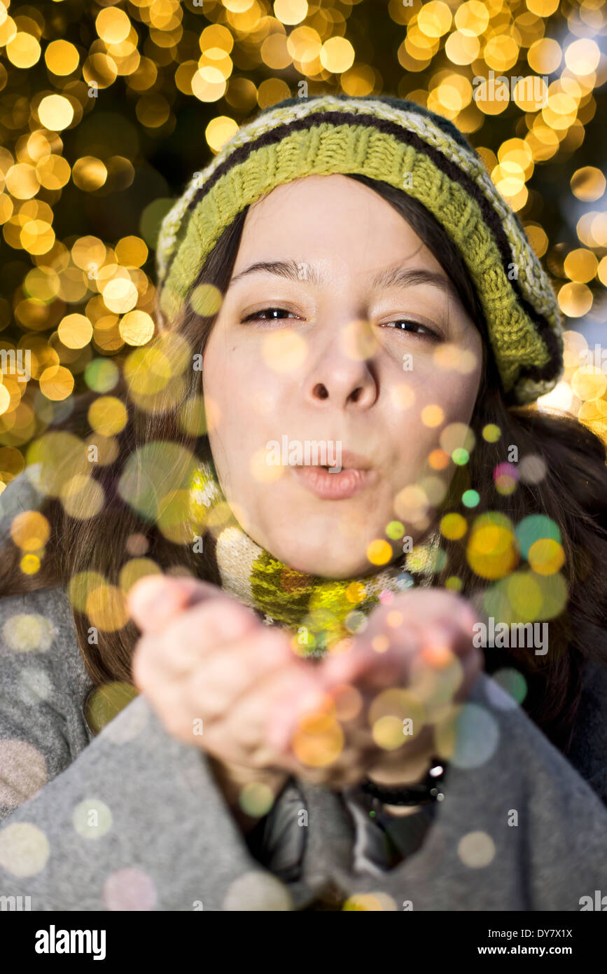 Portrait of young woman blowing golden glitter Banque D'Images