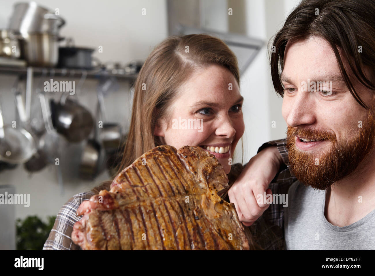 Couple avec grand steak dans kkitchen Banque D'Images