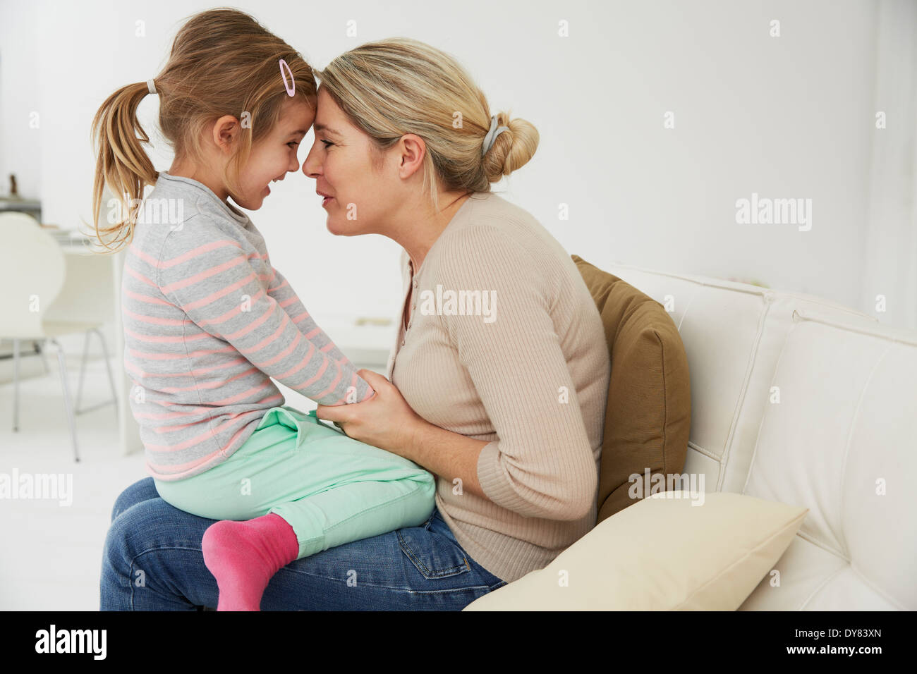 Allemagne, Munich, Mother and Daughter sitting on sofa, câlins Banque D'Images