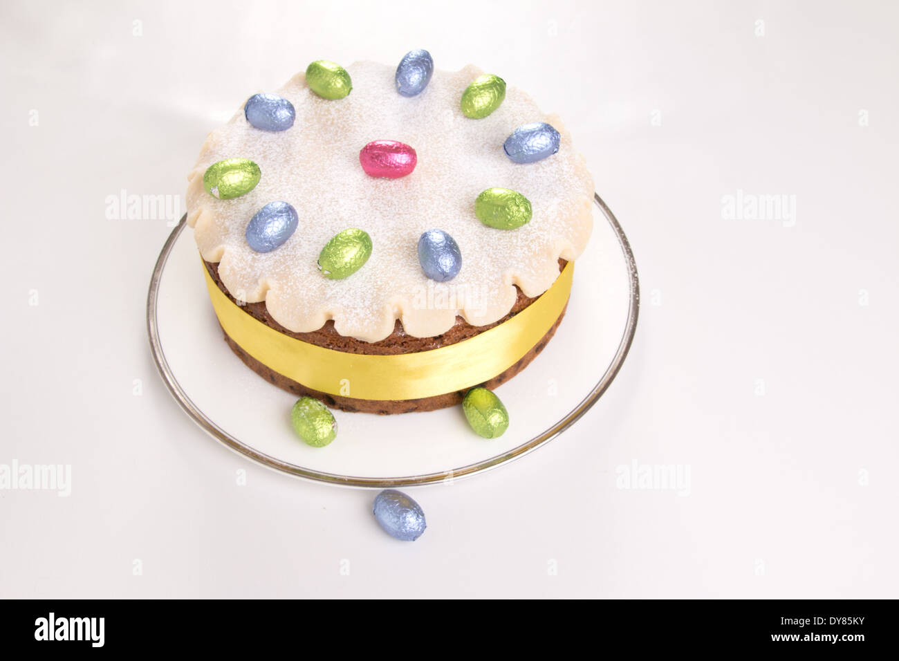 Simnel gâteau décoré avec du massepain et feuilles chocolat oeufs sur une plaque blanche avec fond blanc (19 0F 35) Banque D'Images