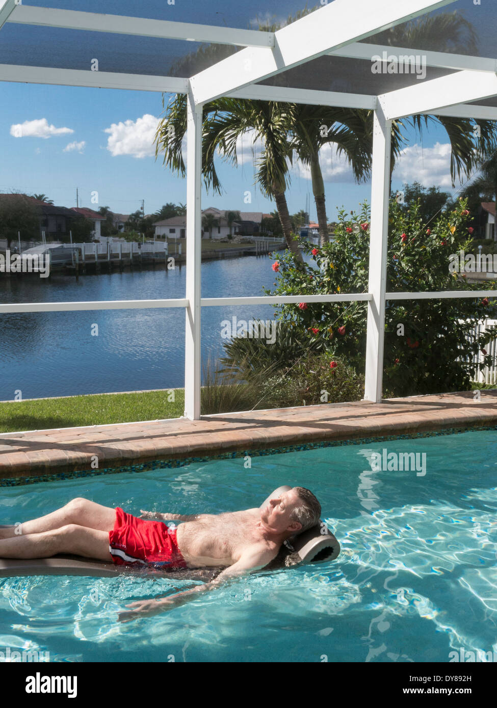Homme mûr se prélasser dans une piscine, Punta Gorda, FL Banque D'Images