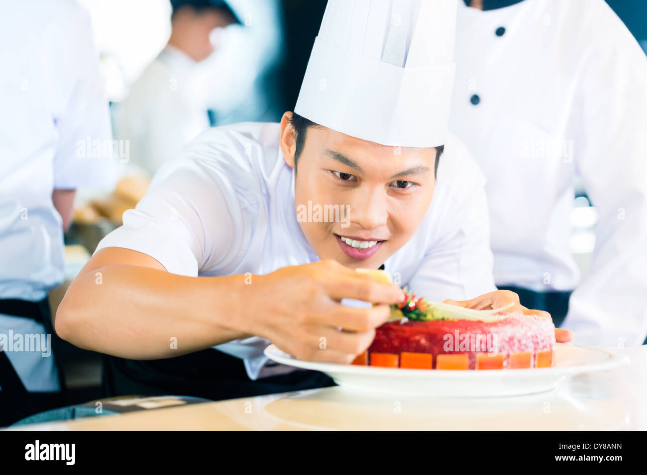 Portrait of Asian chef decorating cake Banque D'Images