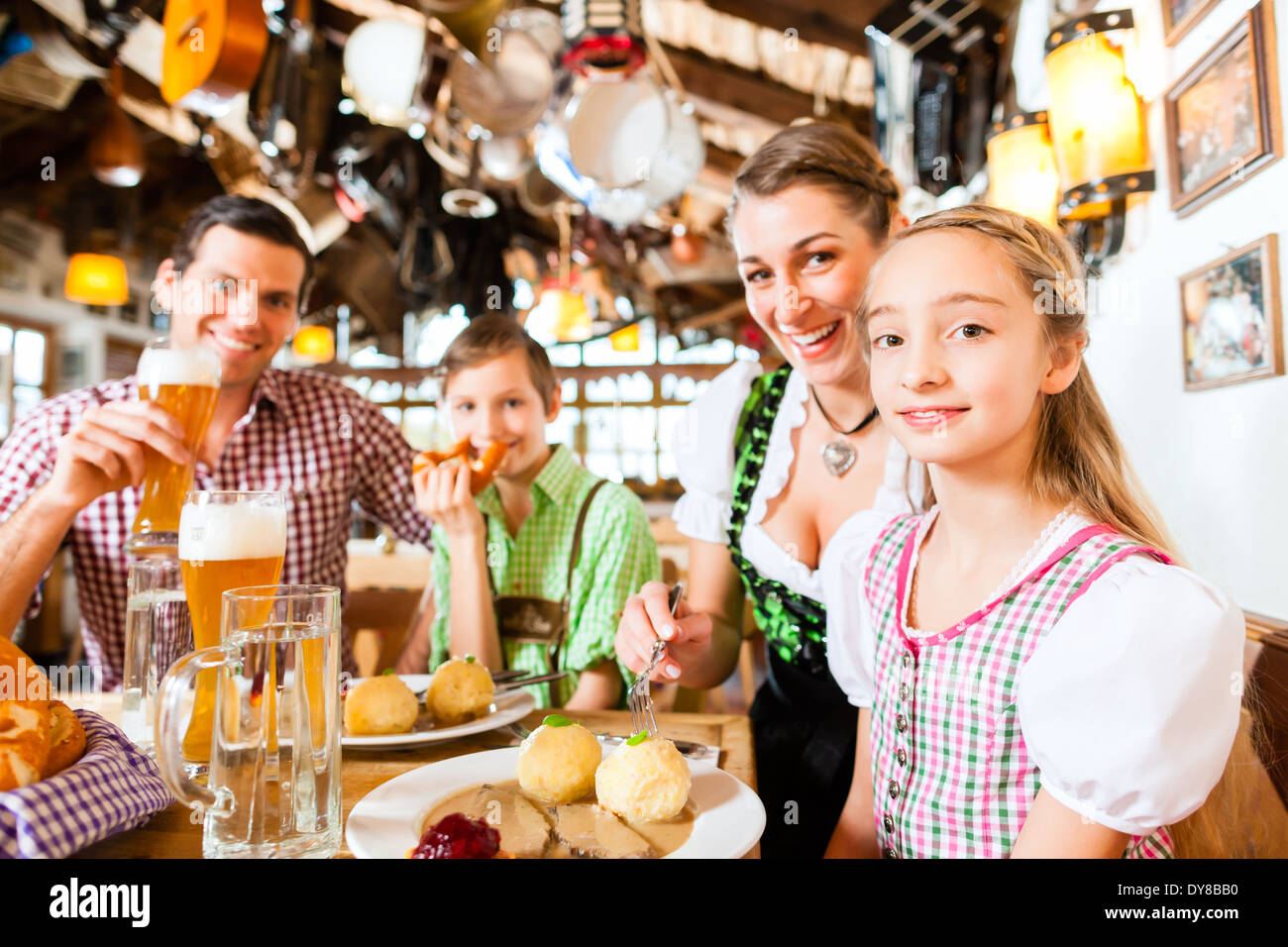 La famille de Bavière ayant repas traditionnel dans un restaurant allemand Banque D'Images