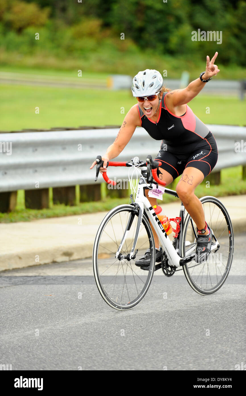 Femme dans une course sur un vélo de triathlon Banque D'Images