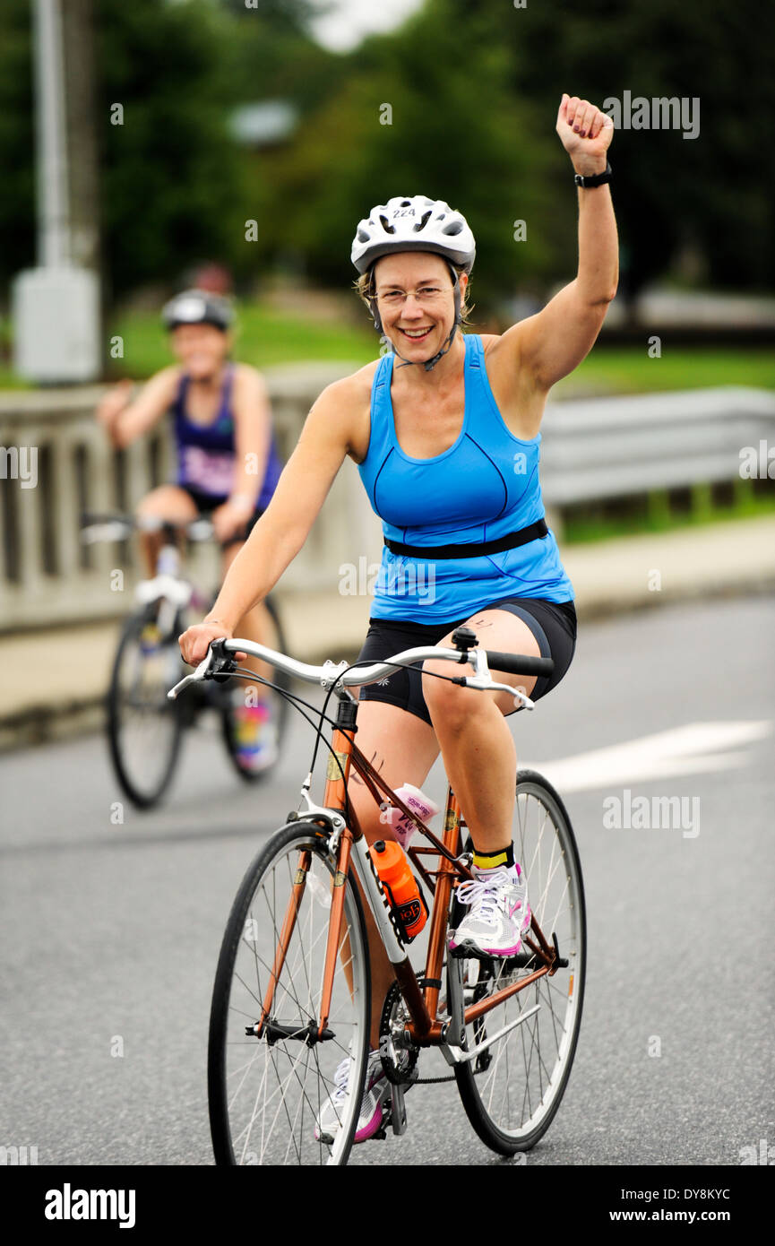 Femme dans une course sur un vélo de triathlon Banque D'Images